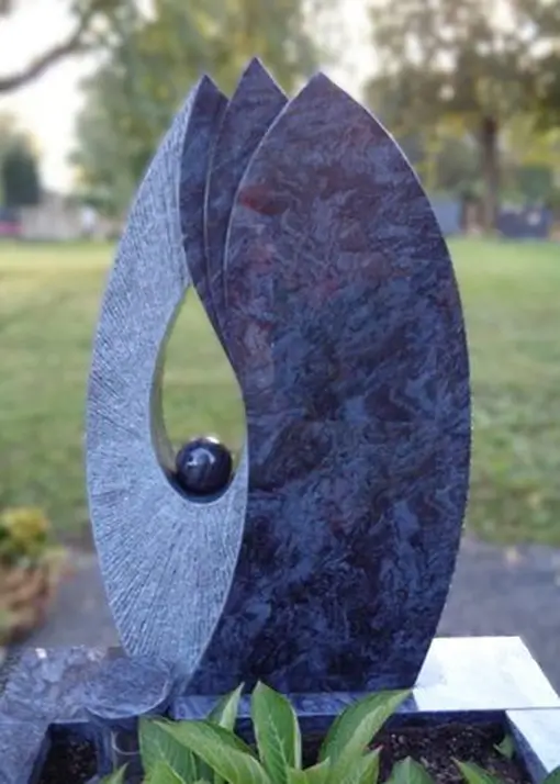 Ein Grabstein aus Marmor in einem Blattdesign mit einer Kugel in der Mitte