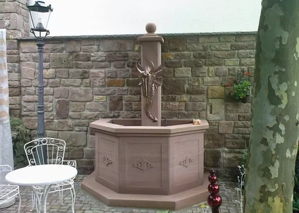 Sanierter historischer Brunnen aus Sandstein mit einem Drachen